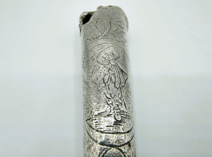 Close-up van zilveren heft met reliëfgravure van een figuur en bloemenmotief.