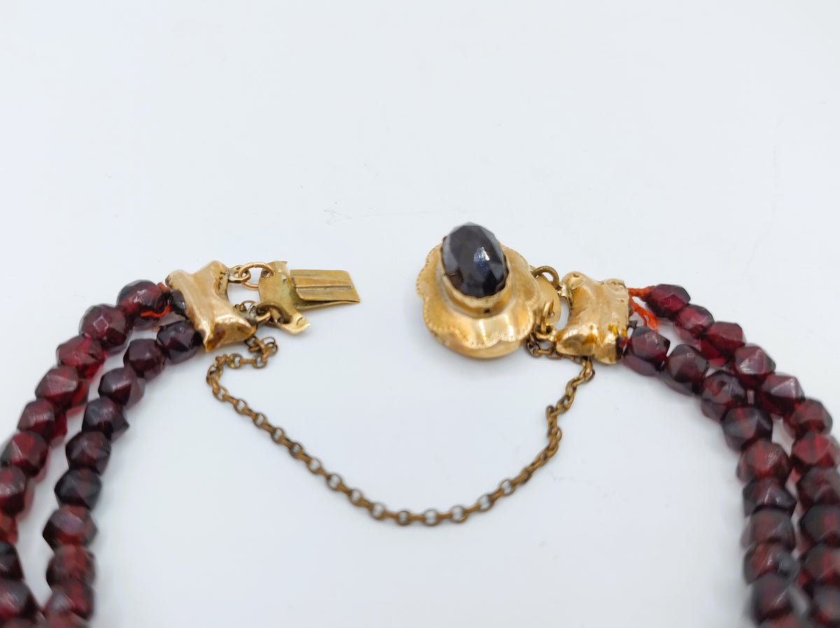Rode glasgranaten armband met goudkleurig slotschakelstuk en zwarte steen