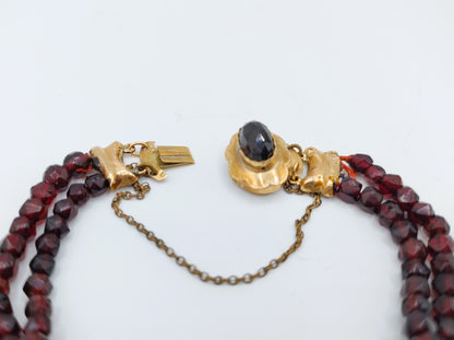 Rode glasgranaten armband met goudkleurig slotschakelstuk en zwarte steen
