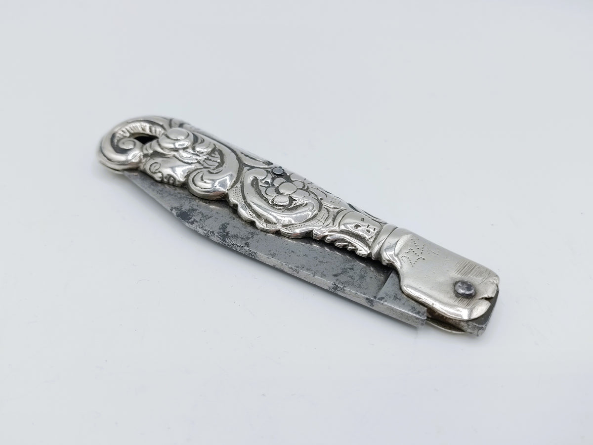 Zilveren zakmes met decoratieve gravures en knop aan het heft