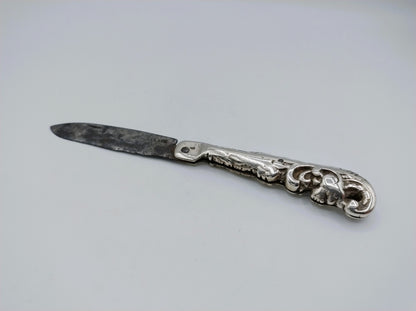 Zilveren zakmes met open mes en gegraveerd handvat, lemmet licht getextureerd