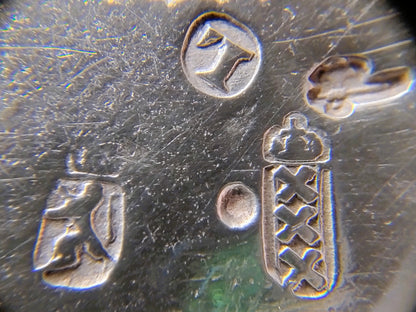 Zilveren stempels en decoratieve markeringen op metalen bodem