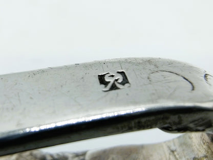 Zilveren tasbeugel, close-up van gegraveerd merkteken op de beugel
