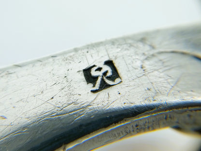 Zilveren tasbeugel, close-up merkteken en zilveren rand