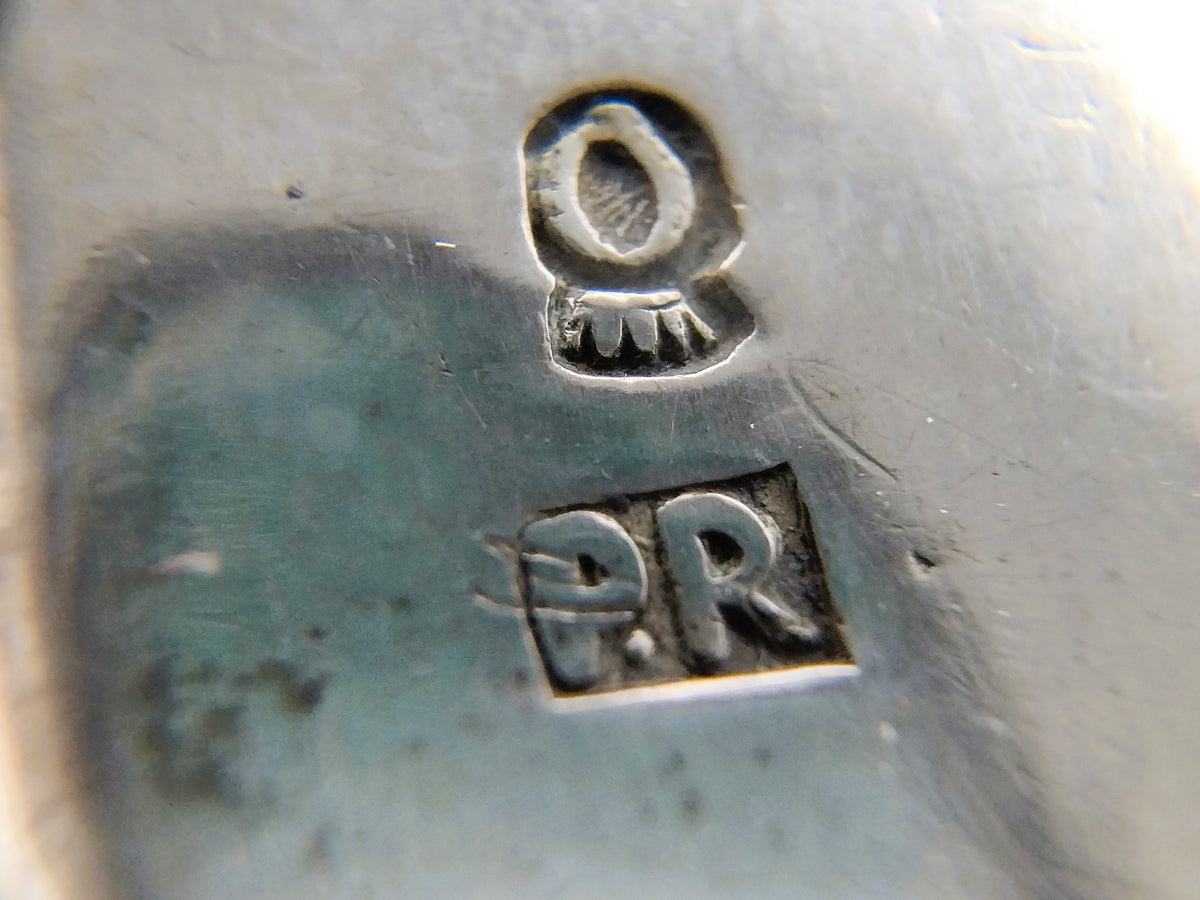 Zilveren keurmerkstempel met 'PR' en oogvormig symbool op chatelaine-onderdeel