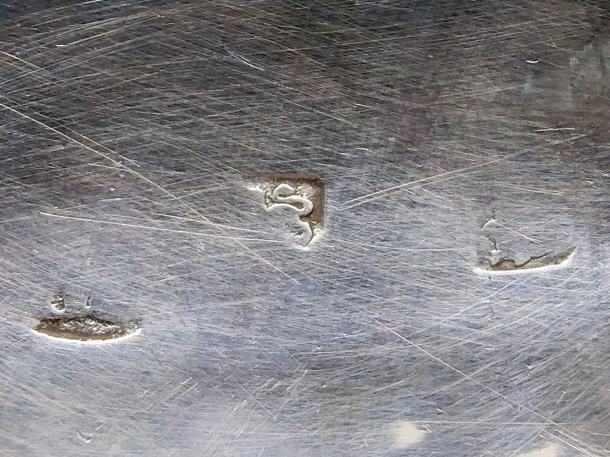 Close-up van gestempelde keurmerken op de zilveren lepelkom