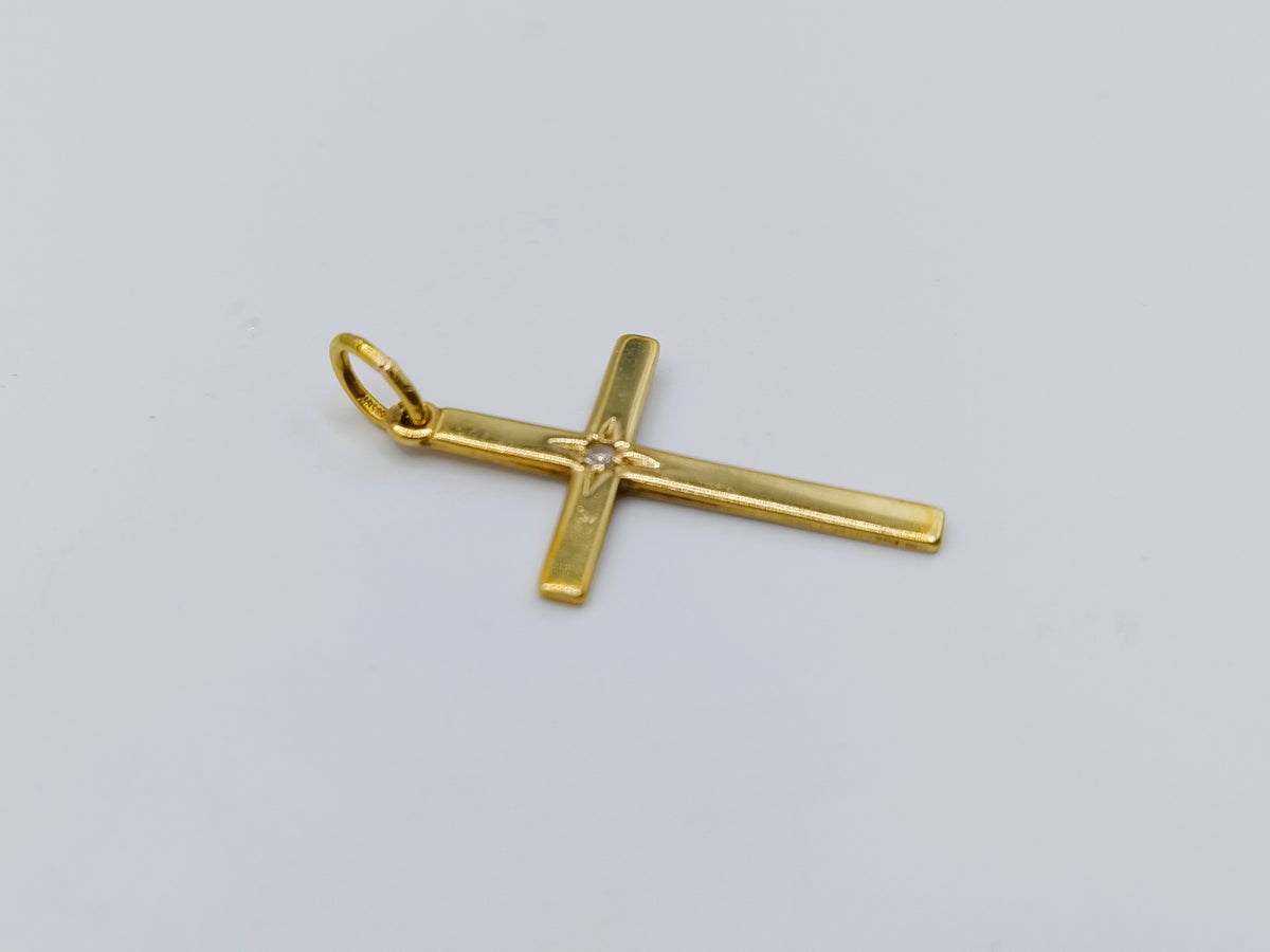 Gouden kruishanger met diamant, liggend in beeld