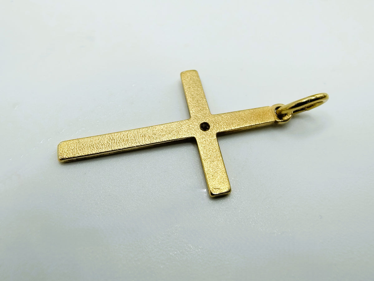 Achterkant van de gouden kruishanger met ophangoog en getextureerd oppervlak