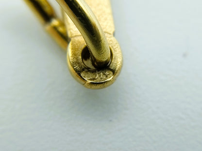 Close-up van het keurmerk bij het ophangoog van de gouden kruishanger