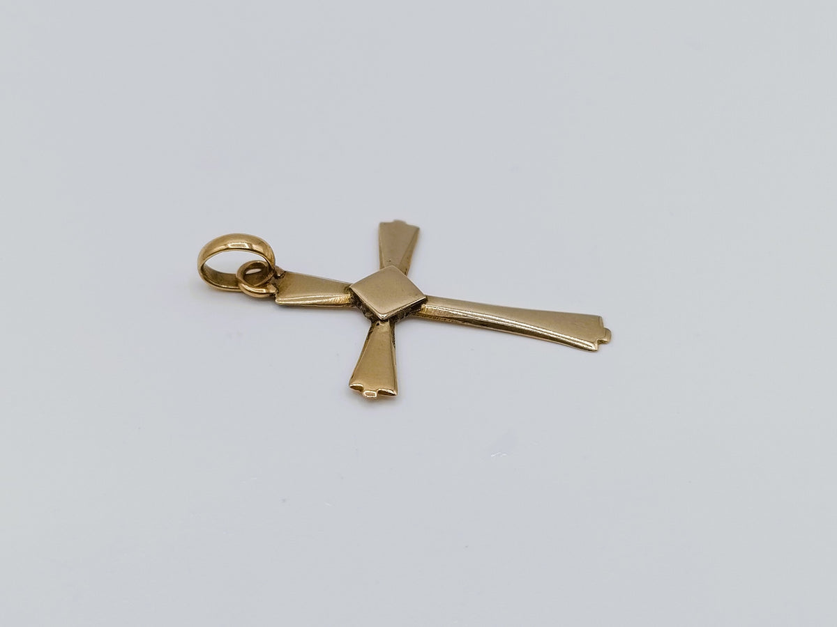 Gouden kruishanger van 14 karaat, liggend onder een hoek met zichtbare ophangring