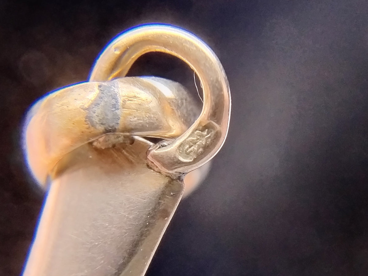 Gouden kruishanger van 14 karaat, close-up van de ophangring en bevestiging
