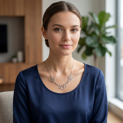 Zilveren designketting met ringvormige schakels, zichtbaar vanaf de borst op model